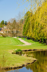 Obraz premium Golf course with gorgeous green and pond.