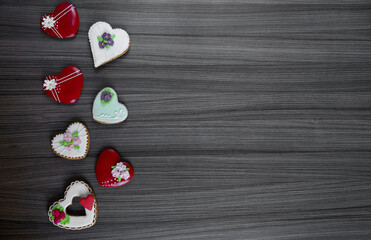 Festive background for text for Valentine's Day in the form of gingerbread in the form of hearts. Multi-colored glaze and decorations. High quality photo