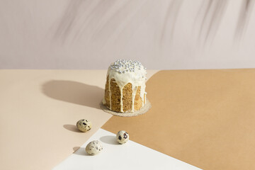 Three quail eggs and traditional easter cake with exquisite taste on a trendy isometric beige background with a shadow on the wall.