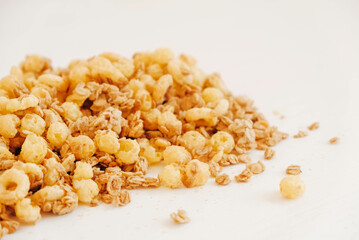 Dry muesli with cornflakes, nuts and raisins on a white background