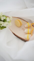 Fototapeta na wymiar Easter setup - eggs and yellow french macarons on white background 