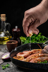 Delicious shrimp with seasoning, Prawns fried with splashes of lemon juice in a freeze motion on a dark background. Seafood appetizer. Culinary, cooking concept