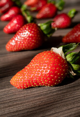 Wooden background for text with red, fresh and ripe strawberries. Summer decoration from berries. High quality photo