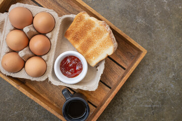 American breakfast ingredients with red eggs on a wooden tray