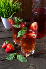 strawberry lemonade with mint poured into glasses on the wooden table