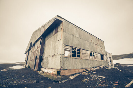 Lost Place, eine alte Walfanghalle aus Wellblech, am schwarzen Strand von Deception Island in der Antarktis