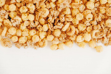Dry muesli with cornflakes, nuts and raisins on a white background