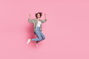 Fototapeta na wymiar Full length photo of young woman jump rejoice success lucky fists hands triumph isolated over pink color background