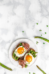 Grilled Toast witch Asparagus, Poached egg, bacon jamon, ham, vertical image. top view. place for text