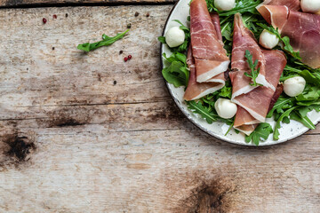 Antipasto salad with prosciutto, mozzarella cheese and arugula, Antipasti, a traditional Italian, Long banner format. top view