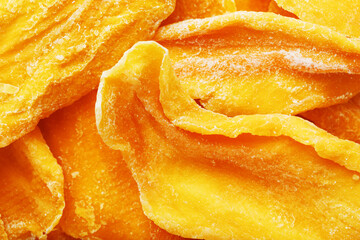 Pieces of sweet dried mango close-up as a background in full screen