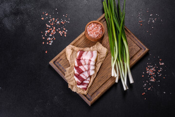 Fresh delicious pork lard with green onions on a wooden cutting board