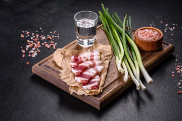 Fresh delicious pork lard with green onions on a wooden cutting board