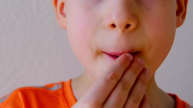 close-up of part of child's face, child, boy 8-10 years old enjoys sweets, wants to eat gelatinous candy, gummy bear, concept of children's delicacy, healthy and unhealthy food, halal food