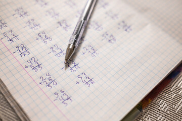 Mathematical examples that the student wrote and solved. Sum and subtraction. Algebra. Pen on a notebook in a box. High quality photo