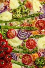 Pie with fresh asparagus, sweet peas, mozzarella and cherry tomatoes. Vegan food recipe background. vertical image. top view