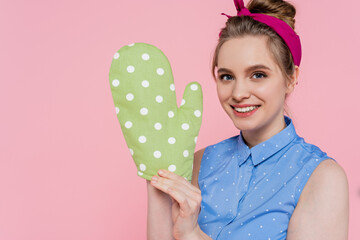 happy young woman with green baking glove isolated on pink.