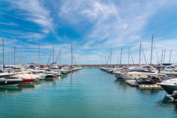 Fototapeta premium View from the harbour of Fuengirola City. Promenade area with restaurants and bars, boats and yachts docked just in front of restaurants. Famous travel destination