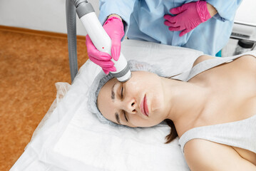 Radio wave face lifting in a cosmetology clinic photo. Skin treatment. Hardware cosmetology.