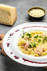 Pasta with grilled shrimps, bechamel sauce, cheese and microgreen, italian cuisine, Food recipe background. Close up