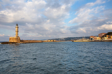 view from the sea to the old stone lighthouse in the small Greek resort town of Rethymno