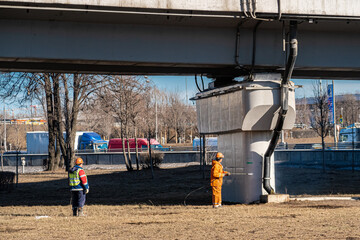 A road worker paints a road bridge pier