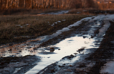 the road after the snow melts in the village. Off road