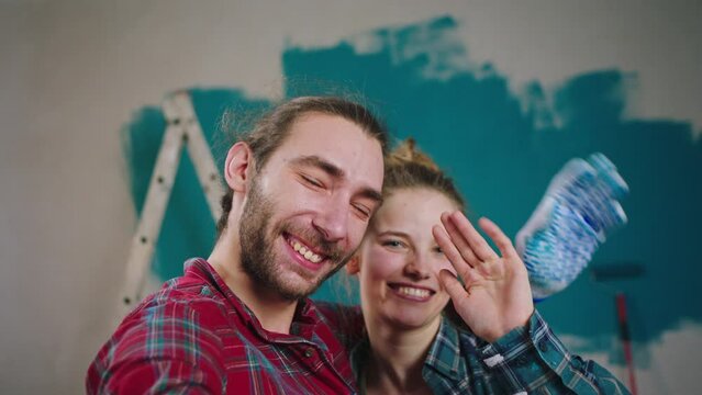 Excited couple at home while painting the walls take a video for memory with camera saying bye they discussing to the camera and have a very excited faces. 4k