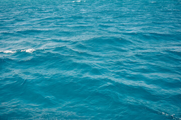 Abstract natural background, surface, texture. Waves of blue sea water. Copy space. Selective focus.
