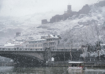 Snowy Tbilisi, Georgia. The central part of the Old City in the snow. Narikala Fortress and Metekhi bridge over Kura river.  - 494755703