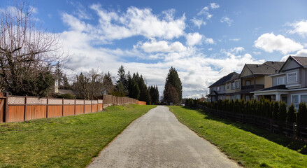 Scenic Path in a Residential Residential neighborhood in Modern City Suburbs. Sunny Winter Day. Fraser Heights, Surrey, Greater Vancouver, British Columbia, Canada.