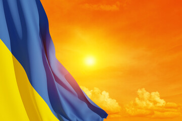 Ukraine flag on the orange sky with the sun. Close up waving flag of Ukraine. Flag symbols of Ukraine.