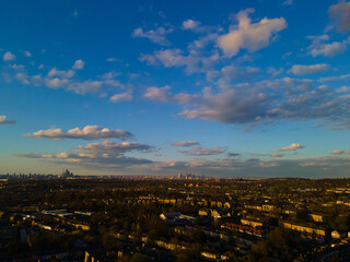 Aerial view of houses in a residential district beneath the blue sky with clouds.
