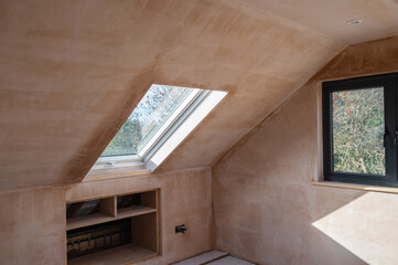 Loft conversion with rounded ceilings, brown plastered walls