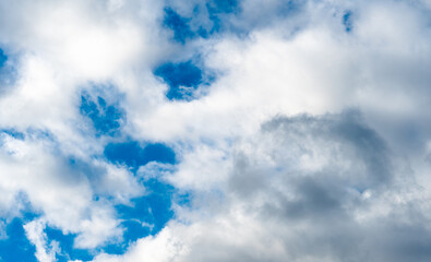 Fluffy white clouds against a blue sky on a warm sunny day. Gentle and slowly floating clouds as a concept of a quiet life.