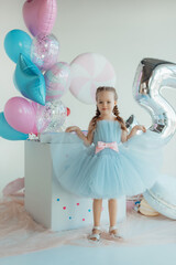 Cute smiling little girl in blue dress. Happy childrens day. Happy birthday.