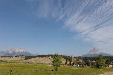 Wispy clouds over mountain meadow in front of Crowsnest Mountain