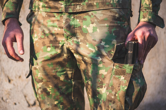 Soldier dressed in camouflage uniform with a bible in his foot pocket