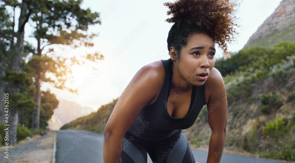 Canvas Prints Get your heart racing. Shot of a sporty young woman taking a break while exercising outdoors.