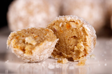 Beautiful sweets with coconut on a white plate on a black background