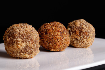 Beautiful candy truffle on a white plate on a black background