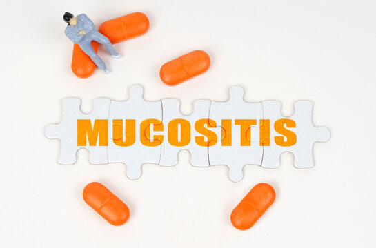 On the white surface of the tablet, a miniature human figure and puzzles with the inscription - Mucositis