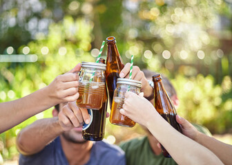 Cheers to summer. Cropped shot of a young group of friends toasting while enjoying a few drinks outside in the summer sun.