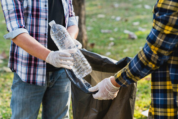 Collecting the garbage and separating waste to freshen the problem of environmental pollution and global warming, plastic waste, care for nature. Volunteer concept of men carrying garbage bags