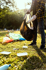 Collecting the garbage and separating waste to freshen the problem of environmental pollution and global warming, plastic waste, care for nature. Volunteer concept of men carrying garbage bags