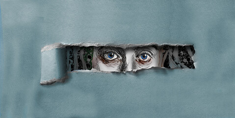 A female with blue eyes peers through a hole torn in cardboard in this 3-d illustration. - obrazy, fototapety, plakaty