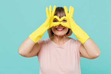 Elderly housewife woman 50s in pink t-shirt gloves doing housework cover eyes with fingers like...