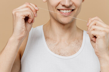 Cropped photo shot young man 20s perfect skin wear undershirt hold using dental floss smile...