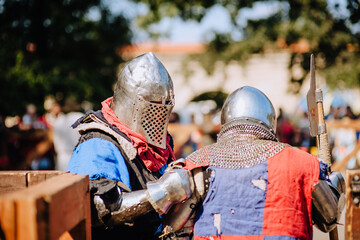 Two strong knights, warriors stand on the battlefield after defeating a rival, in armor with an ax...