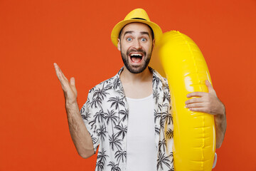 Young excited tourist man wear beach shirt hat hold inflatable ring travel abroad on weekends...
